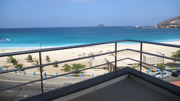 A balcony with a view of a beach and ocean. - Complexo Multiuso Copacabana (São Vicente)