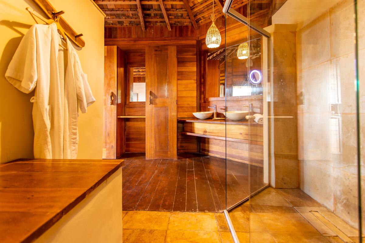 A wooden interior with a glass partition, wooden flooring, and a wooden ceiling.