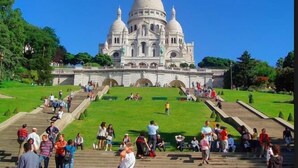 A large, white, domed building with multiple smaller domes, surrounded by a well-maintained lawn and a stone staircase leading up to it. - Hotel de France (Paris)