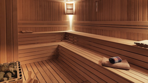 Een sauna met houten banken en een handdoek op één van de banken.