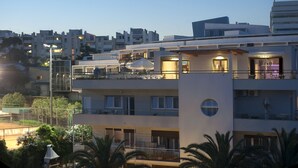 A multi-story hotel with balconies, outdoor seating, and a view of the surrounding urban area. - Boban Luxury Suites (Split)