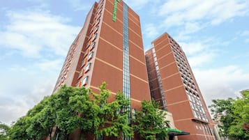 Un edificio de gran altura con varios pisos, que destaca por un cartel vertical en la fachada.