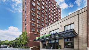 A Holiday Inn Express hotel with a modern facade, large windows, and a covered entrance. - Holiday Inn Express Shanghai New Jinqiao by IHG (Shanghai)