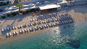An aerial view of a coastal hotel with multiple buildings, a beach with sun loungers, and a pool. - Akkan Beach Hotel (Bodrum)