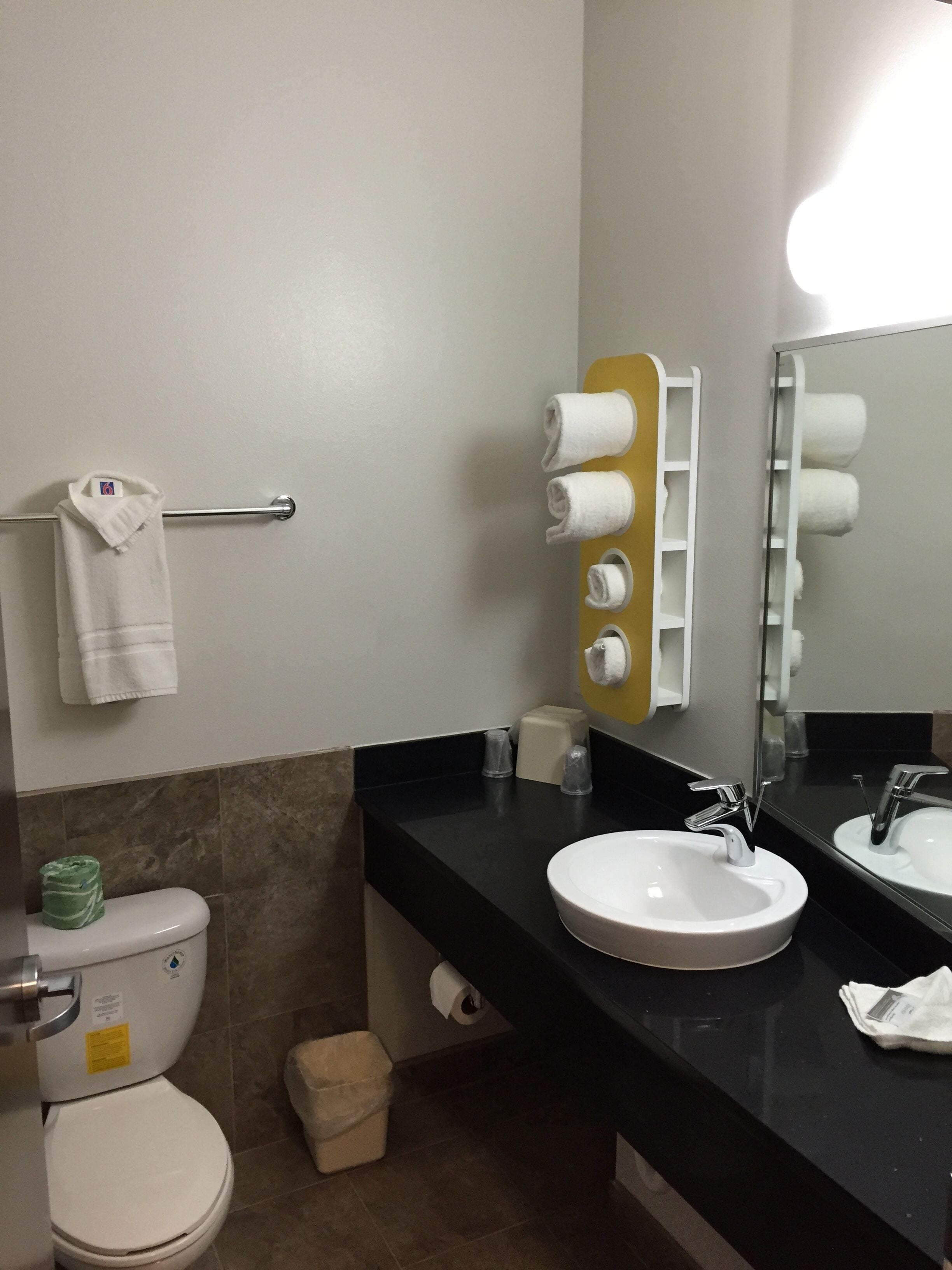 Un baño con dos lavamanos, un inodoro, un perchero para toallas y un espejo.