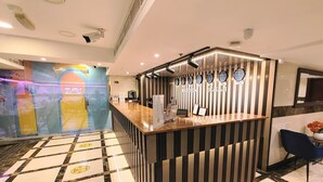 Ein Hotel-Empfangsbereich mit einer Rezeption, Uhren und einem Check-in-Schalter.