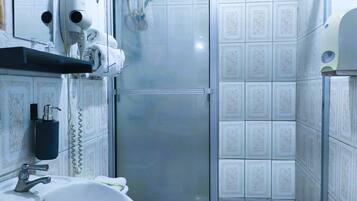 A bathroom with a sink, towel rack, hair dryer, and a hand dryer.