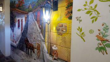 A mural with a horse and cart, a person sitting, and birds.