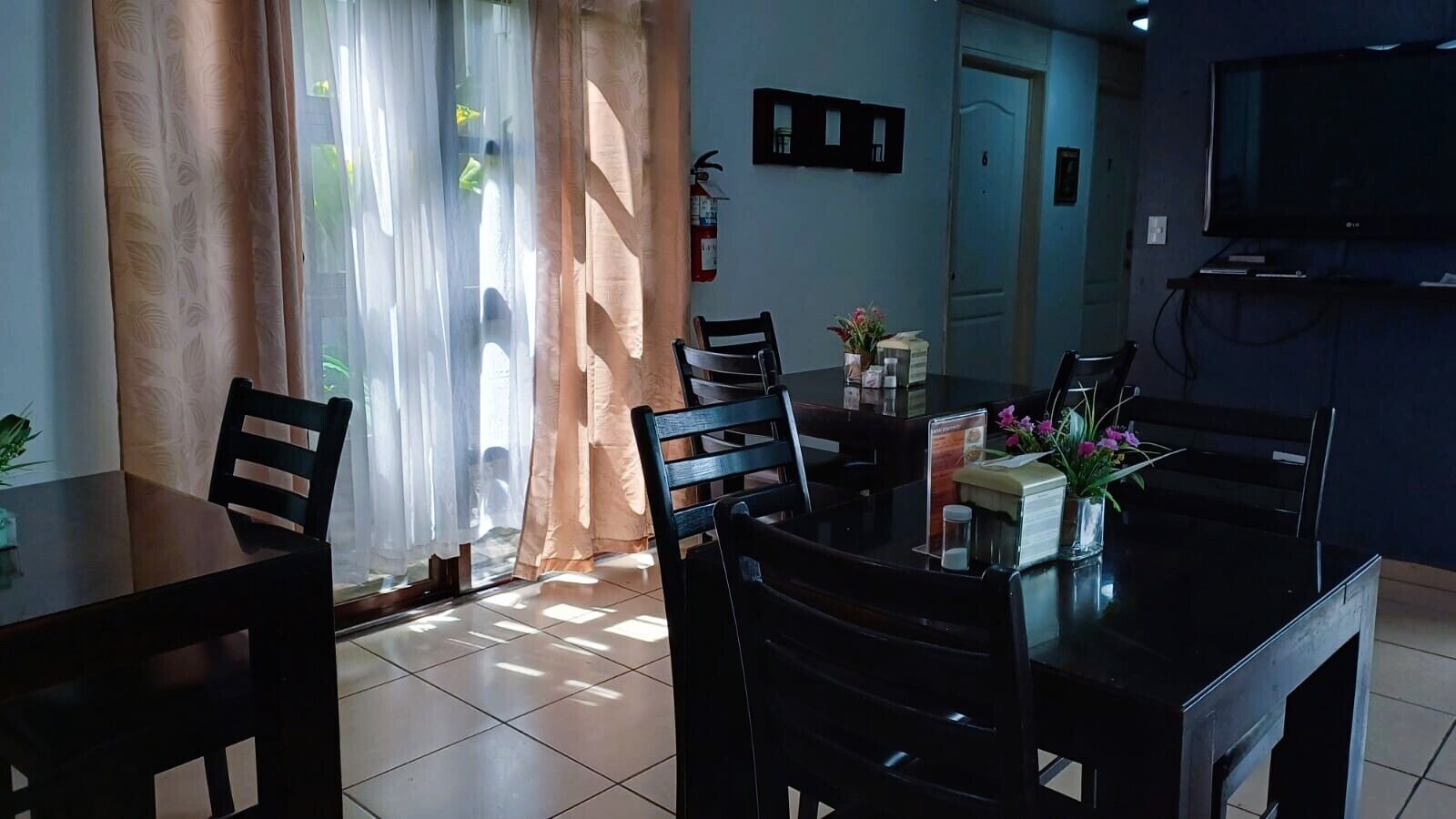 Un comedor con mesa, sillas y televisión.