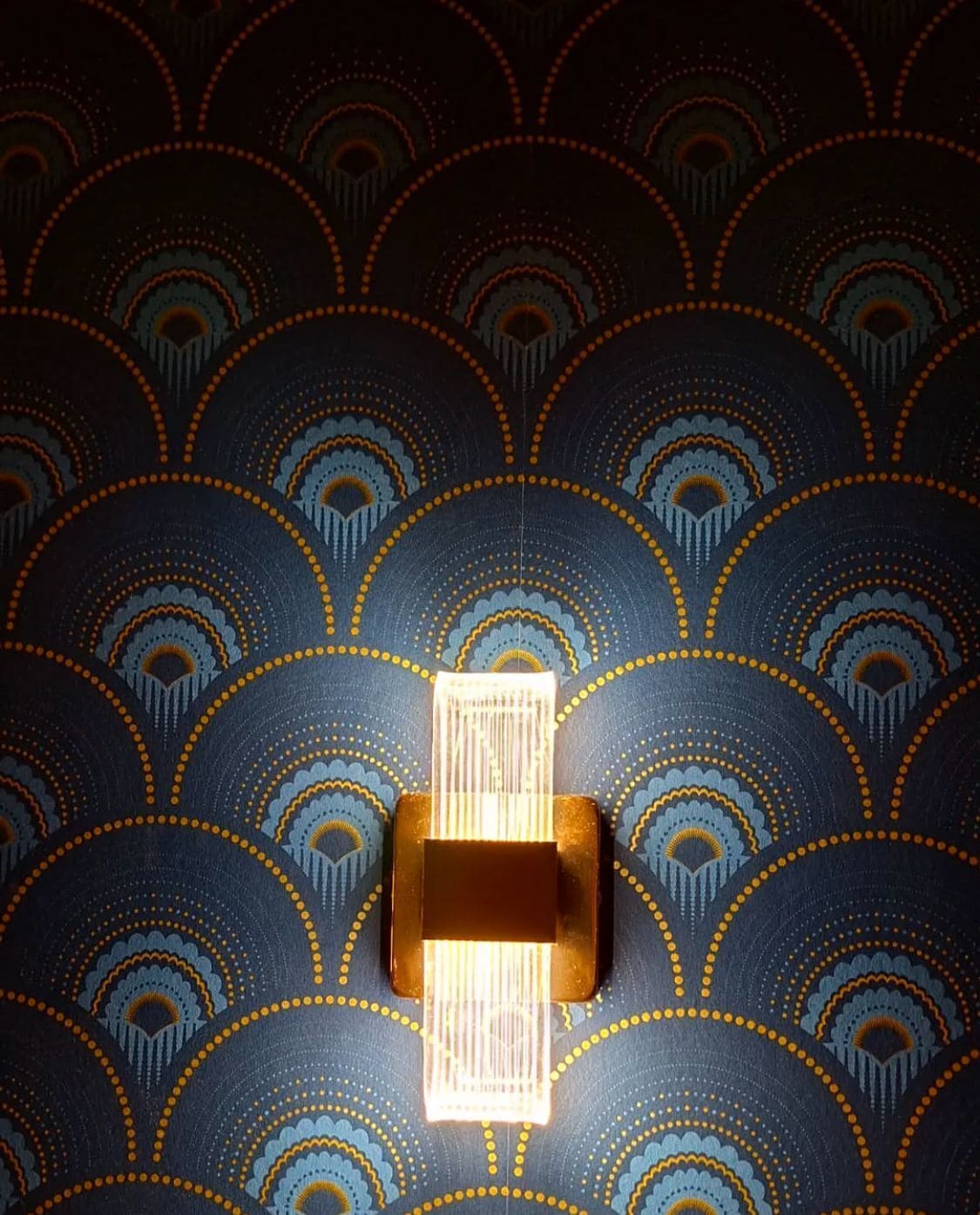 A wall with a geometric pattern and a light fixture.