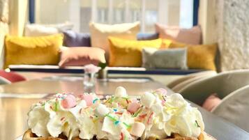 Un postre sobre un plato en una habitación con vistas a un edificio a través de una ventana.