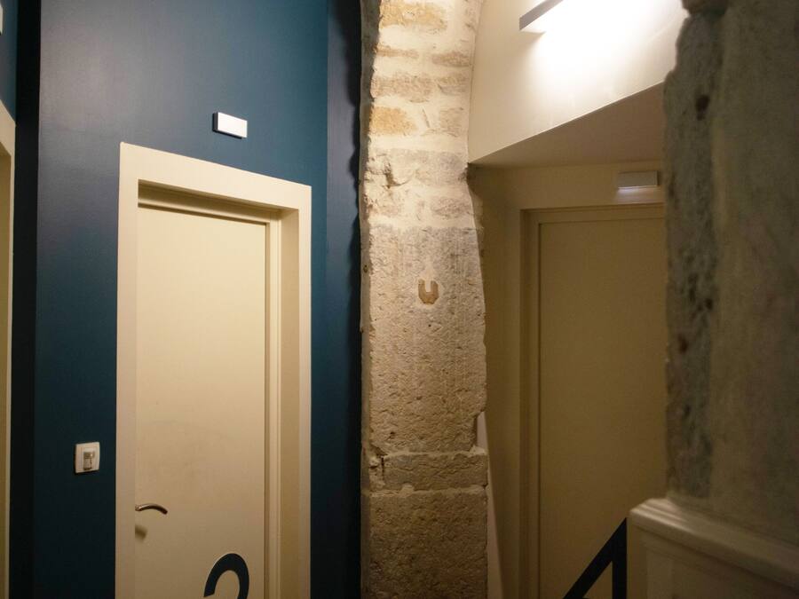A hallway with doors numbered 3 and 4, a stone archway, and a blue wall.