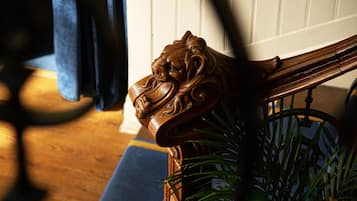 Una silla de madera con un diseño de cabeza de león tallada.