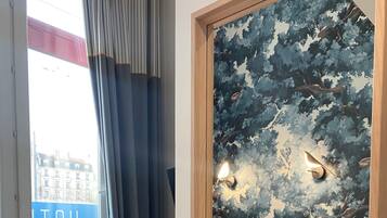 Une chambre d’hôtel avec un lit, un bureau et une fenêtre avec des rideaux.