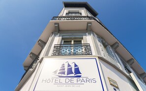 A hotel sign with a ship logo and the name "HOTEL DE PARIS".