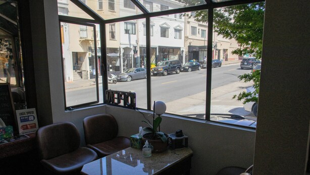 A room with a large window, a table, and several chairs. - Pacific Heights Inn (San Francisco)
