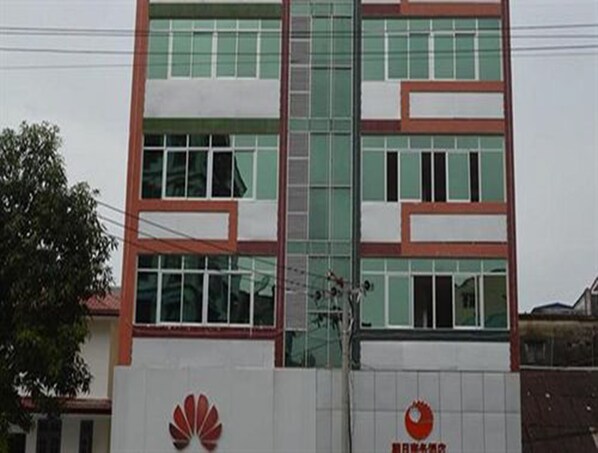 A multi-story building with a glass facade and a red logo on the lower part. - Good Luck Hotel (Yangon)