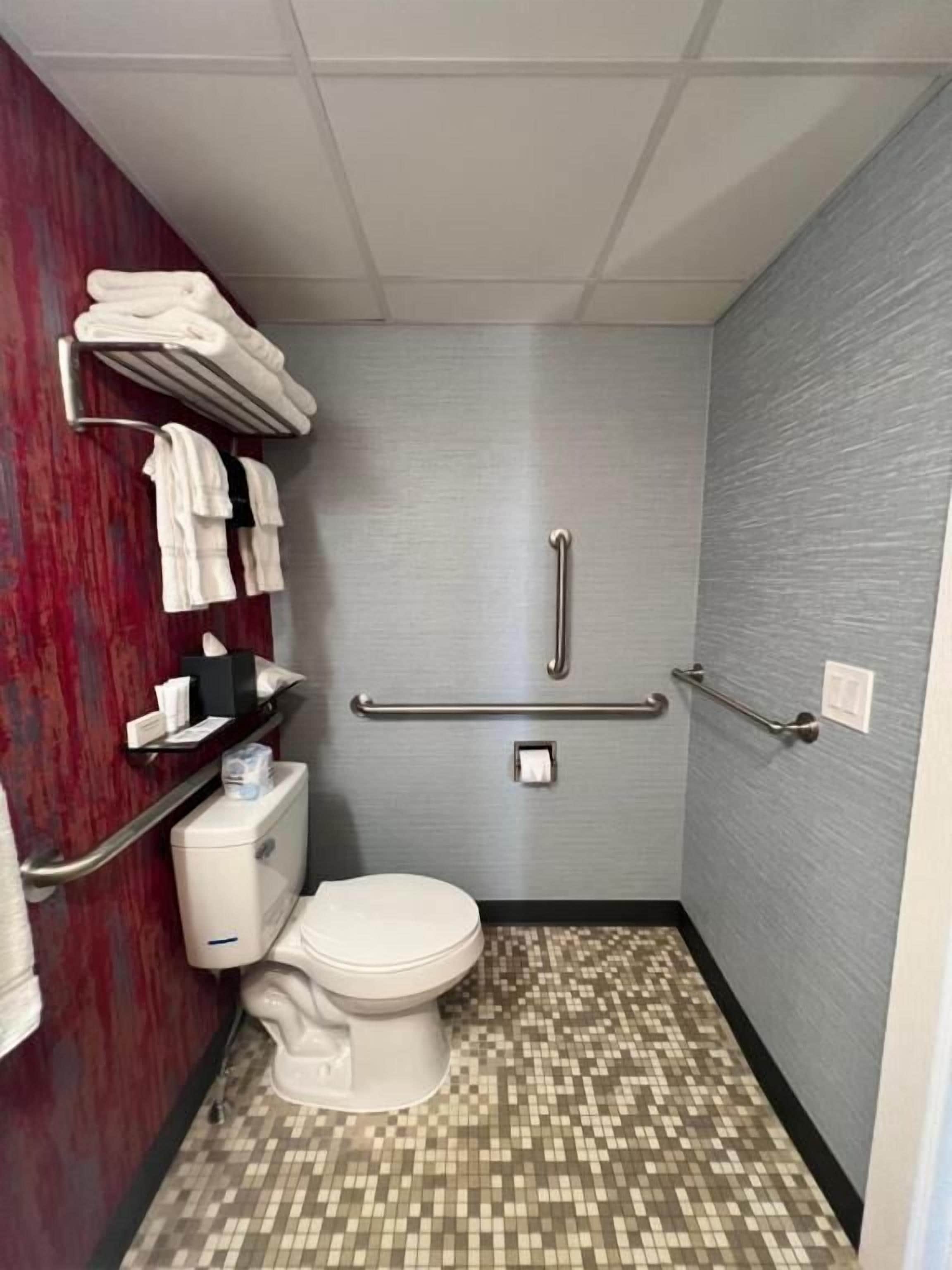 Un bagno piccolo e funzionale, con il water, un asciugamani ad aria e un portasciugamani.