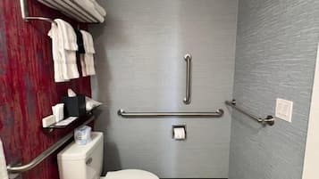 Ein kleines, kompaktes Badezimmer mit Toilette, einem Händetrockner und einem Handtuchhalter.