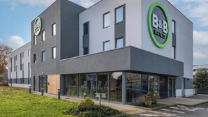 A modern B&B hotel with a flat facade, large windows, and a green circular logo. - B&B HOTEL Laval Ouest (Laval)