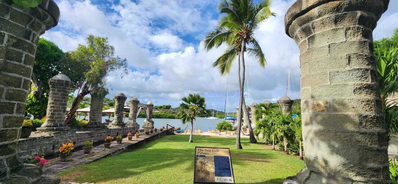 A historical site with stone columns and a signboard.