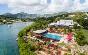 A resort with a swimming pool, outdoor seating, and a view of the water and mountains. - Admiral's Inn and Gunpowder Suites (English Harbour)