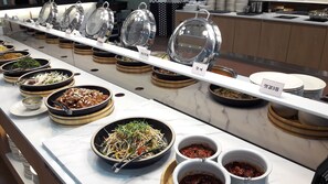 A buffet with various dishes and condiments, including a salad, noodles, and sauces. - Stellar Marina Hotel (Incheon)