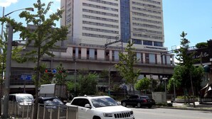 Un grand hôtel au design moderne, avec de nombreux étages et une enseigne bien visible au sommet.