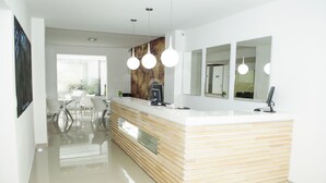 Een moderne keuken met een houten aanrecht, witte stoelen en hanglampen.