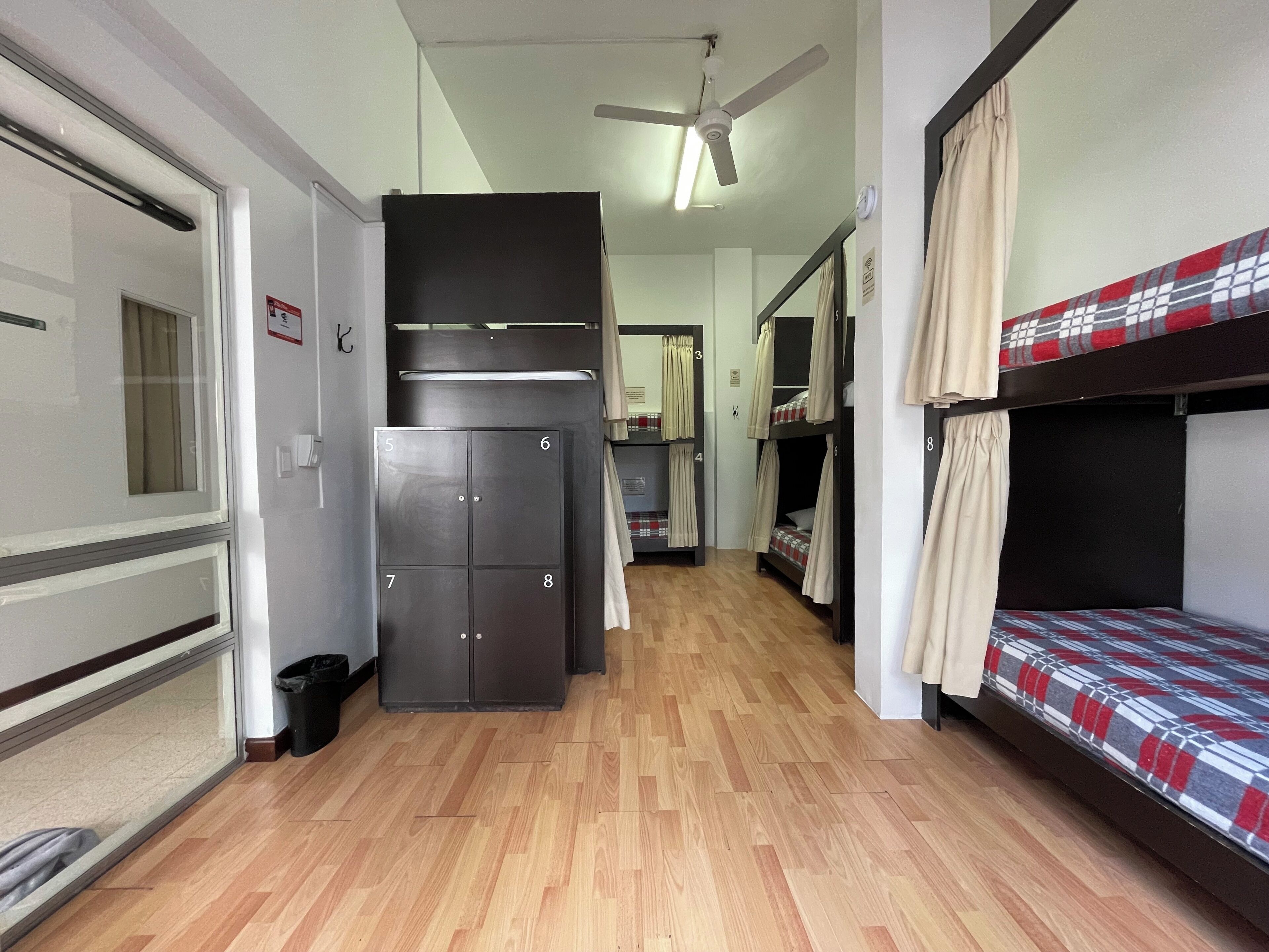 A corridor with bunk beds, a wardrobe, and a ceiling fan.