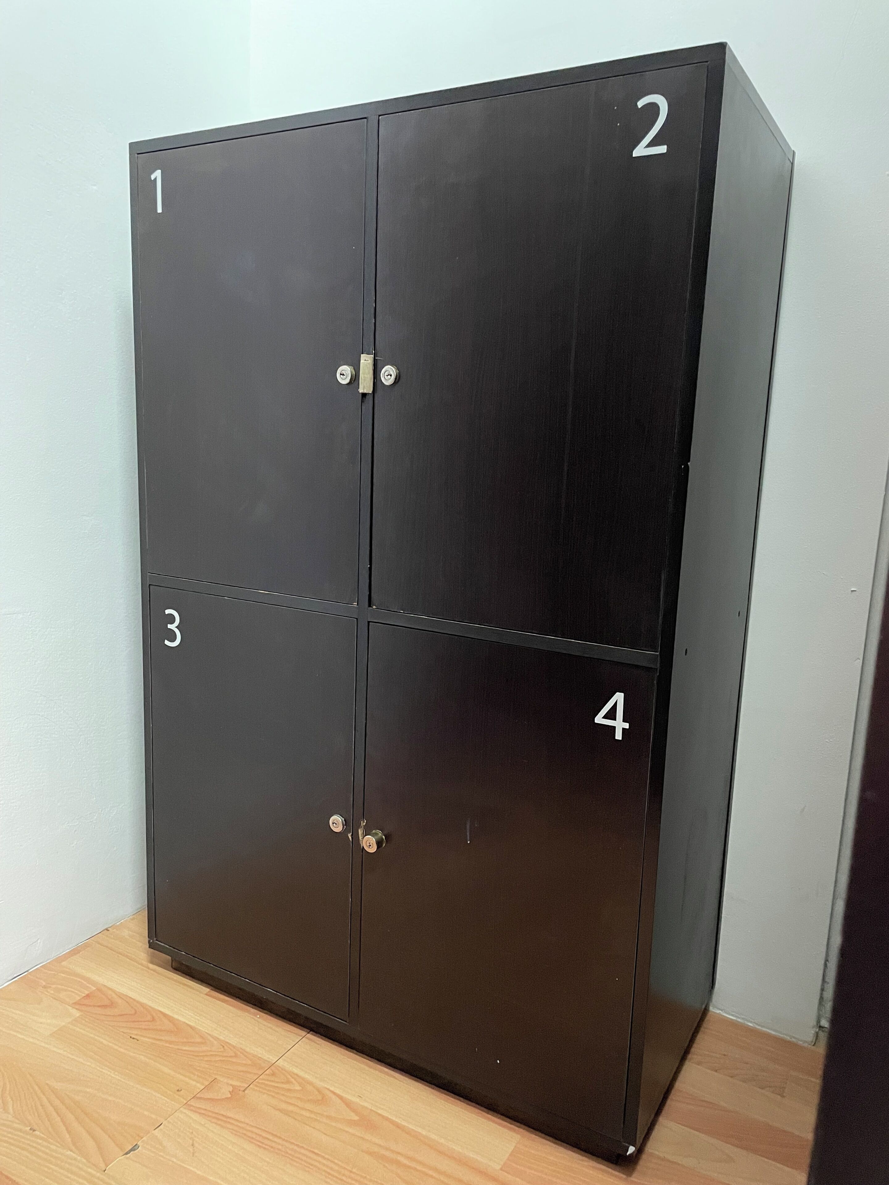 A four-door metal wardrobe with numbered compartments.