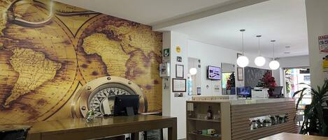 A reception area with a large world map on the wall, a reception desk, and a coffee machine.