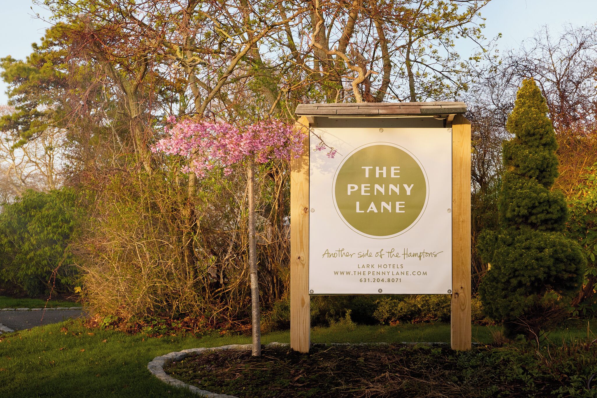 A sign for The Penny Lane Lark Hotel, indicating it's a part of the Hampton's hotel chain.