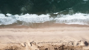 A beach with waves crashing onto the shore. - The Penny Lane (Hampton Bays)