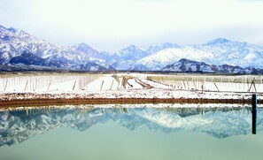 Um lago calmo refletindo montanhas cobertas de neve.