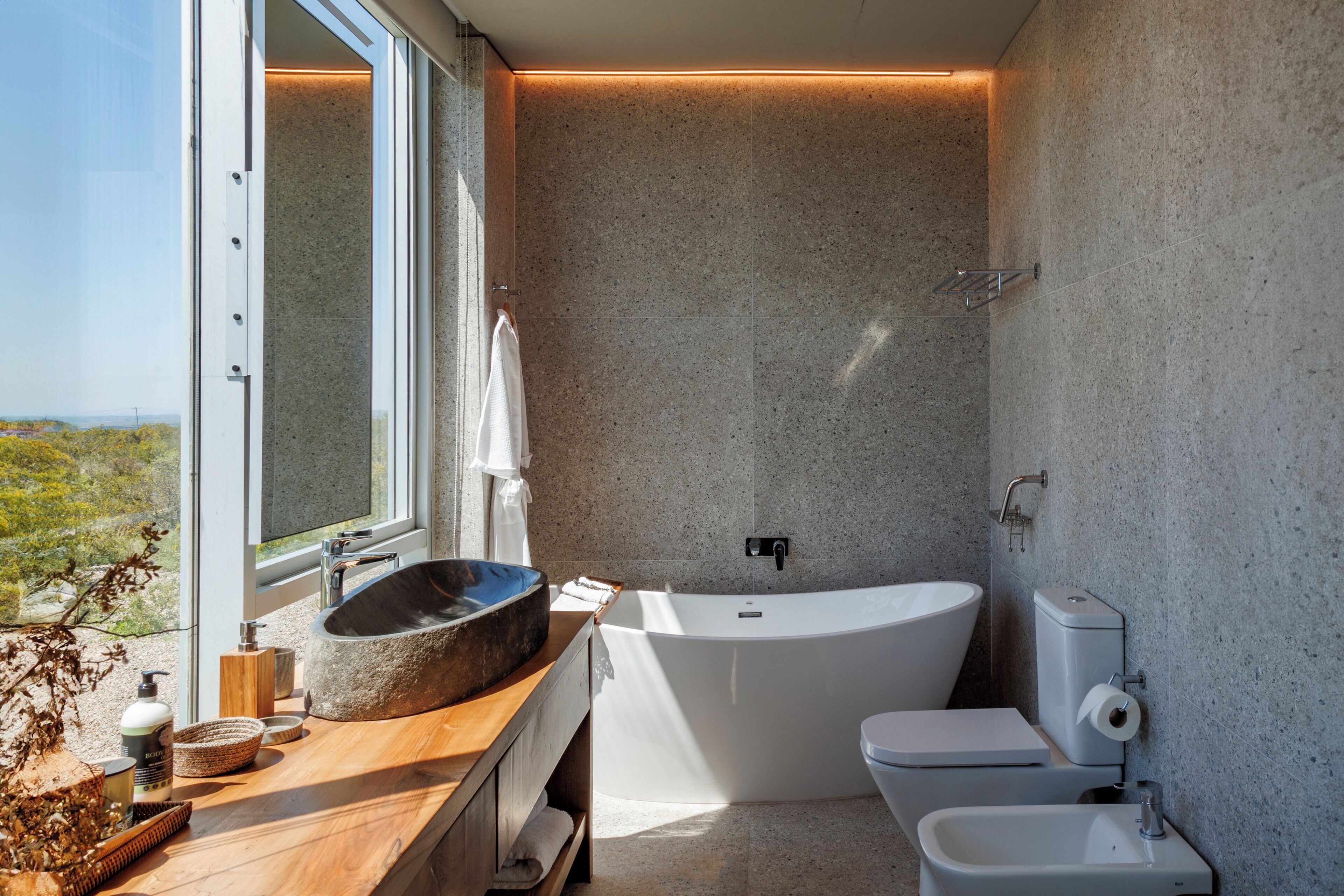 Une salle de bain moderne avec une baignoire sur pieds, un grand lavabo et des toilettes.