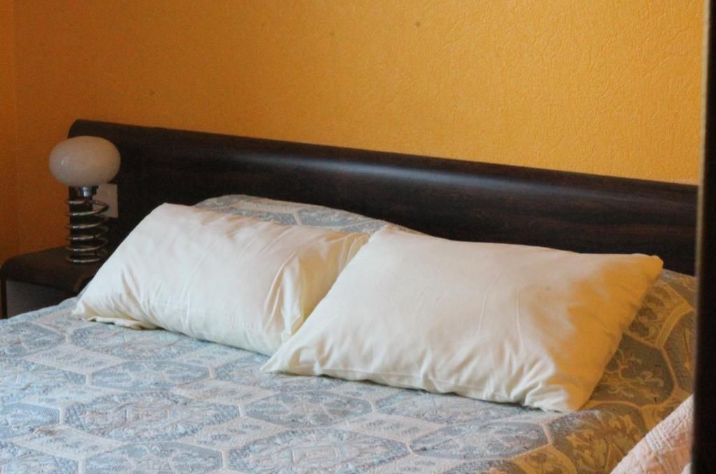 Una cama con una colcha estampada y dos almohadas.