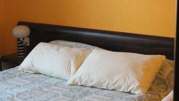 Una cama con una colcha estampada y dos almohadas.