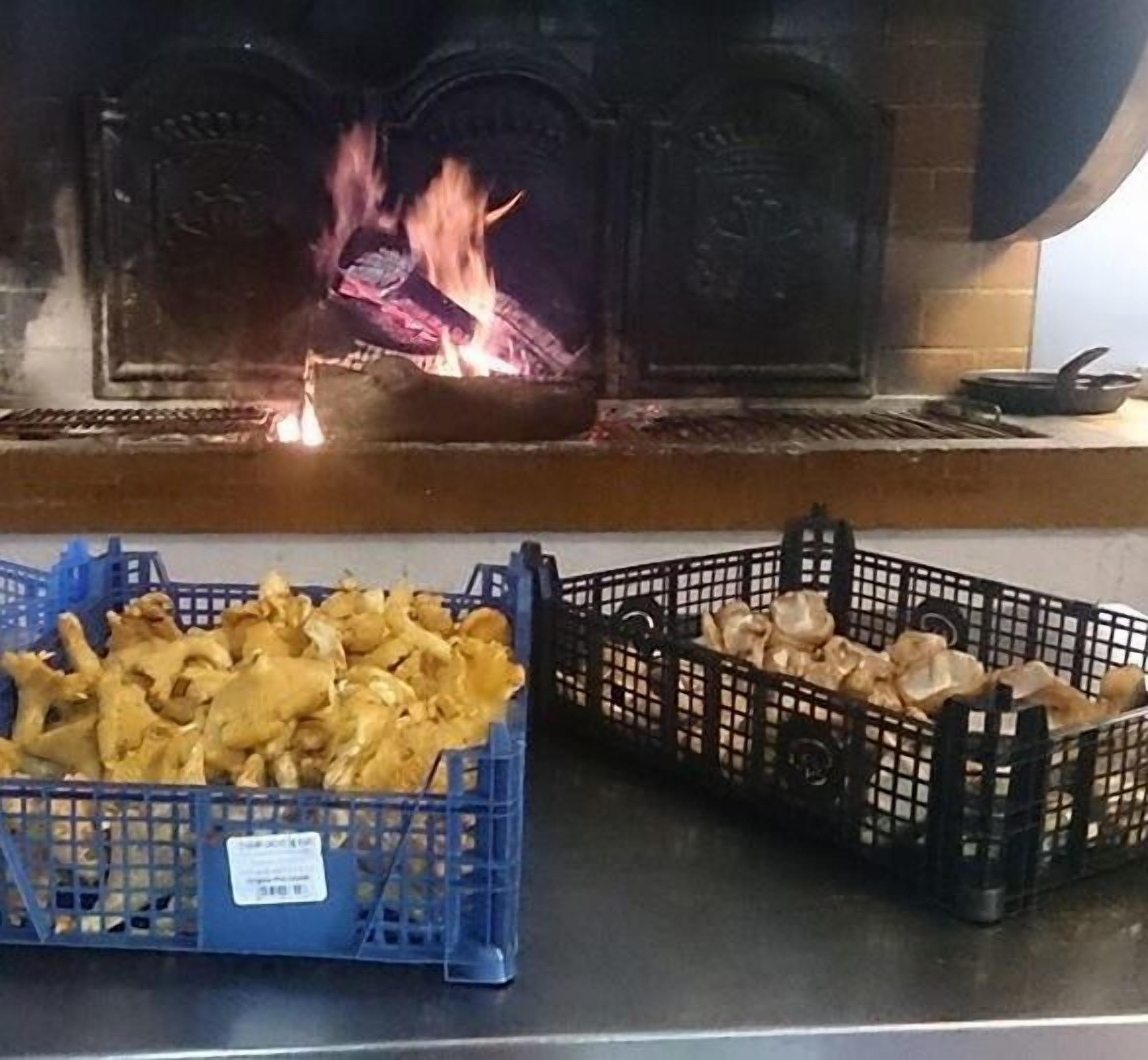 Ett kök med en vedspis och två korgar fulla med matvaror.