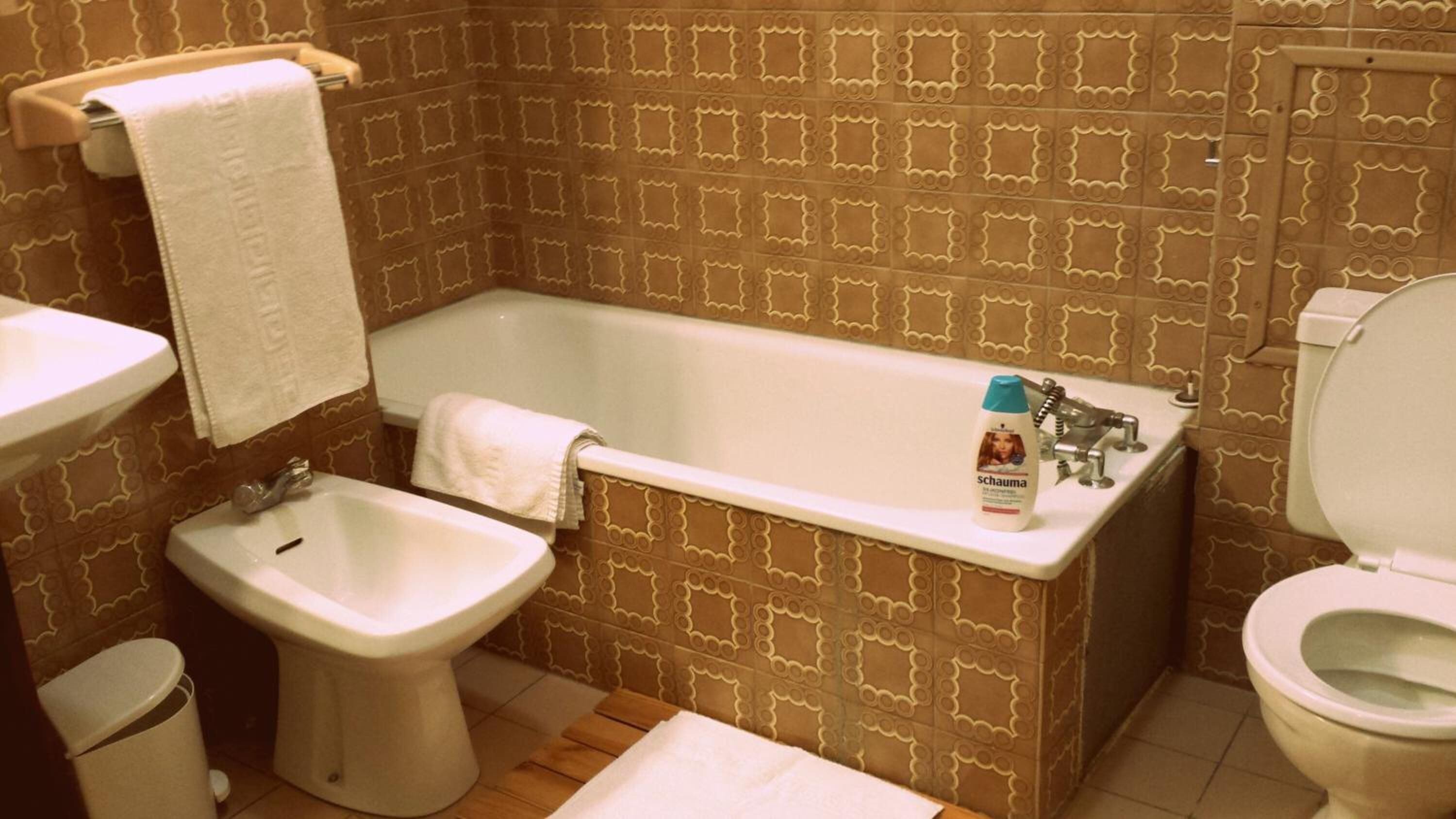 Un baño con bañera, lavabo, bidé e inodoro.