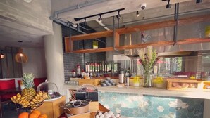 Una cocina moderna con una mesa de madera que muestra frutas y una estación de café.