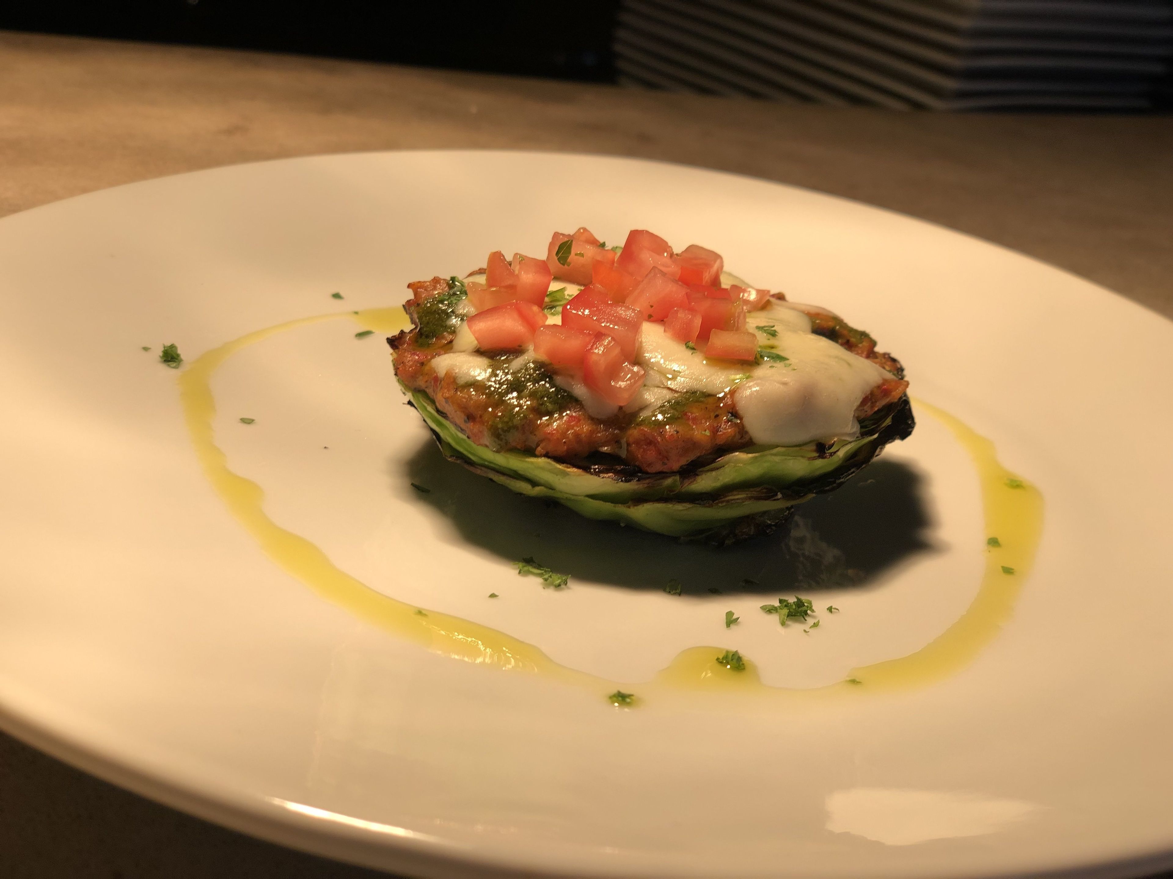 A dish on a white plate with a drizzle of sauce and garnish.