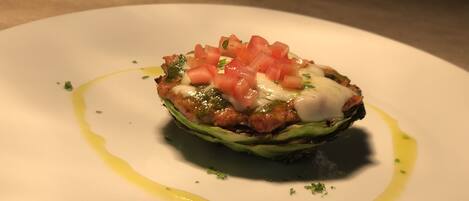 A dish on a white plate with a drizzle of sauce and garnish.