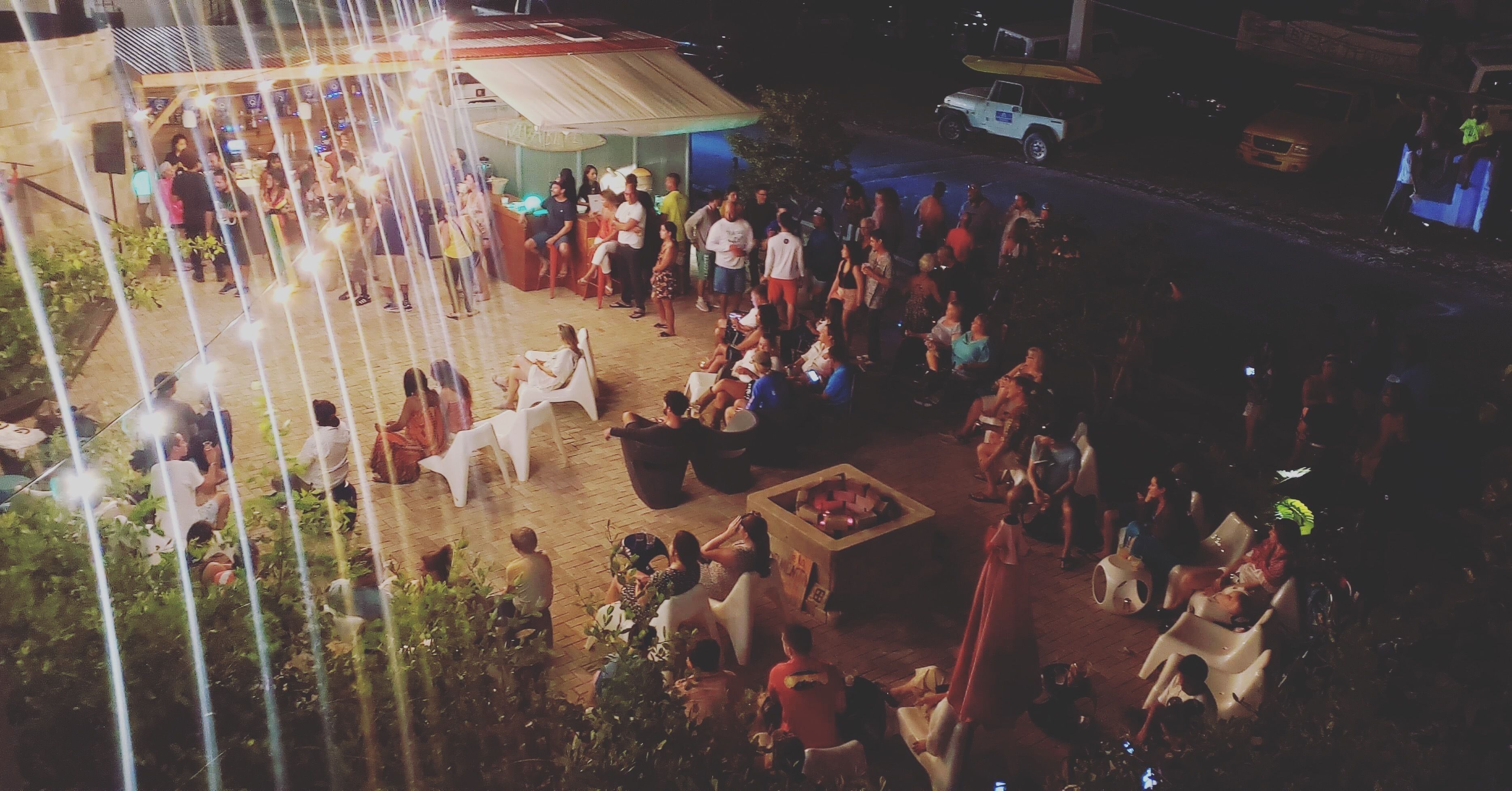 An outdoor gathering area with seating arrangements and a stage for performances.