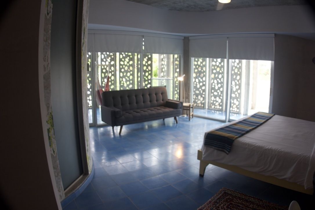 Une chambre avec un lit, un canapé et une grande fenêtre donnant sur un beau paysage.