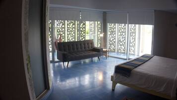Une chambre avec un lit, un canapé et une grande fenêtre donnant sur un beau paysage.