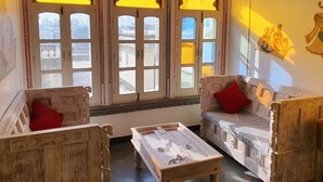 Ein traditionell eingerichtetes Zimmer mit aufwendigen Holzmöbeln, darunter eine Couch und Sessel sowie ein Couchtisch.