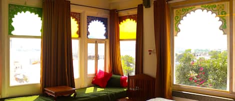 A room with a bed, a small table, and a window with curtains.
