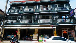 A multi-story building with balconies, a storefront, and a sign indicating availability for rent. - Evelyn Residence (Pattaya)