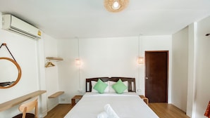 Ein Hotelzimmer mit Bett, Schreibtisch, Stuhl und einer Tür.